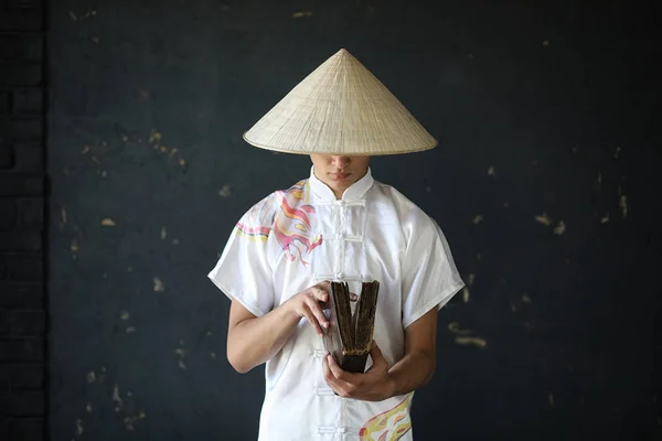 Ázsiai fiatal szerzetes, kalap, fekete falon — Stock Fotó