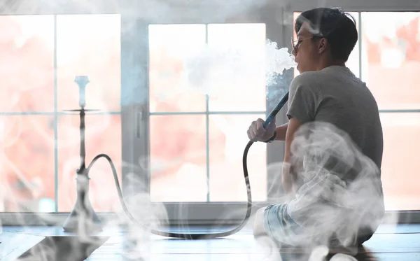 Man in sunglasses smoking a hookah — Stock Photo, Image