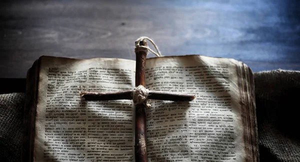 Religiöses altes Buch auf einem Holztisch. ein religiöses Kreuz mit gebundenem Witz — Stockfoto