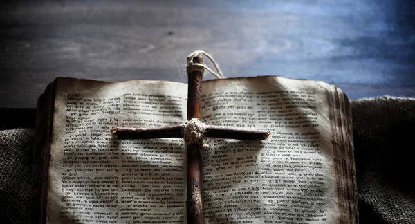 Livro velho religioso em uma mesa de madeira. Uma cruz religiosa amarrado sagacidade — Fotografia de Stock