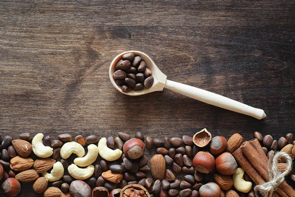 Olika nötter på ett träbord. Ceder, cashew, hasselnöt, walnu — Stockfoto