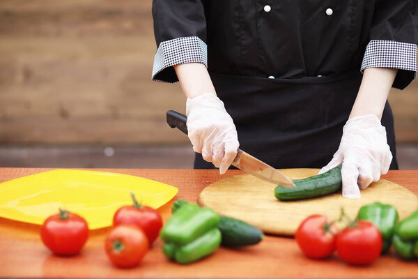 The cook cuts fresh farm vegetables