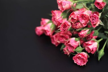 Mat siyah bir arka plan üzerinde kırmızı gül buketi