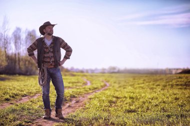 Bir alanda gün batımında ayakta kovboy