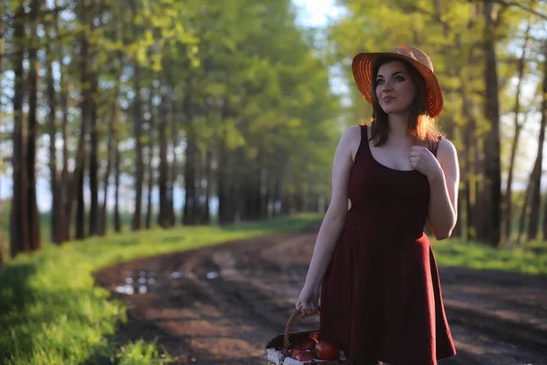 Une fille avec un chapeau lors d'une promenade dans le parc. Une fille avec une promenade de panier — Photo