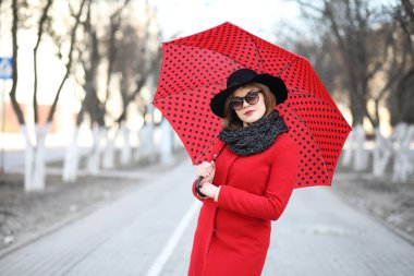 Güzel kız şehirde bir şemsiye ile bir yolda