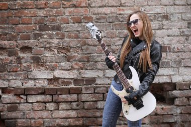  Bir gitar ile deri ceketli bir rock müzisyen kız 