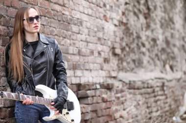  Bir gitar ile deri ceketli bir rock müzisyen kız 