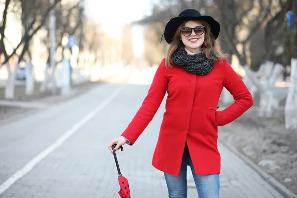 Vacker flicka på en promenad med ett paraply i staden — Stockfoto