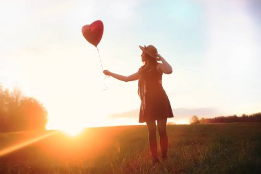 Parkta bir yürüyüş üzerinde şapkalı bir kız. Bir kızla bir sepet yürüyüş