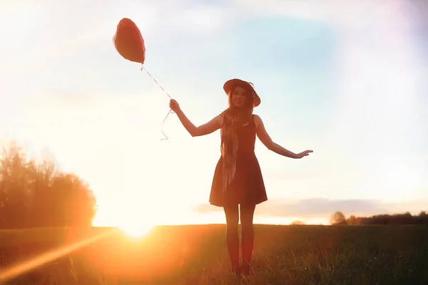 Una ragazza con un cappello mentre passeggia nel parco. Una ragazza con un cesto a piedi — Foto Stock