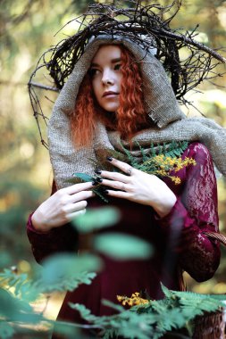 Kızıl saçlı cadı bir ritüel bir kristal top ile tutar