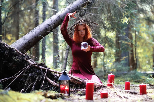 De roodharige heks houdt een ritueel met een kristallen bol — Stockfoto