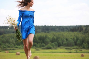 Genç tatlı kız bir alanda gün batımında koşmak