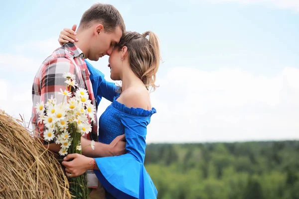 Couple amoureux dans un champ au coucher du soleil — Photo