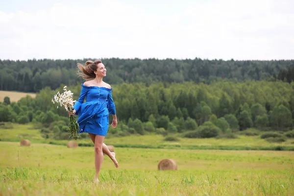 Jeune fille mignonne courir dans un champ au coucher du soleil — Photo