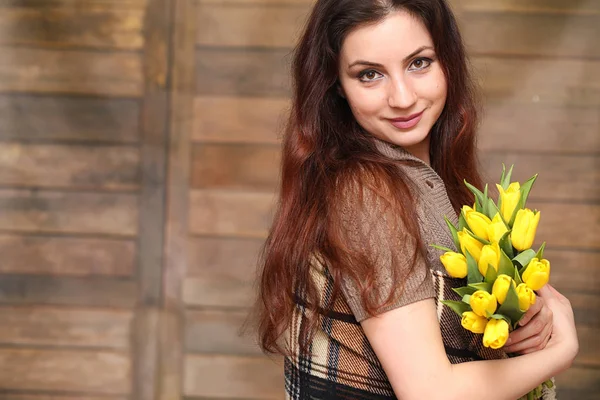 Chica con un ramo de tulipanes amarillos. Chica con un regalo de flor — Foto de Stock