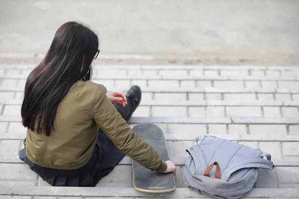 A young hipster girl is riding a skateboard. Girls girlfriends f — Stock Photo, Image