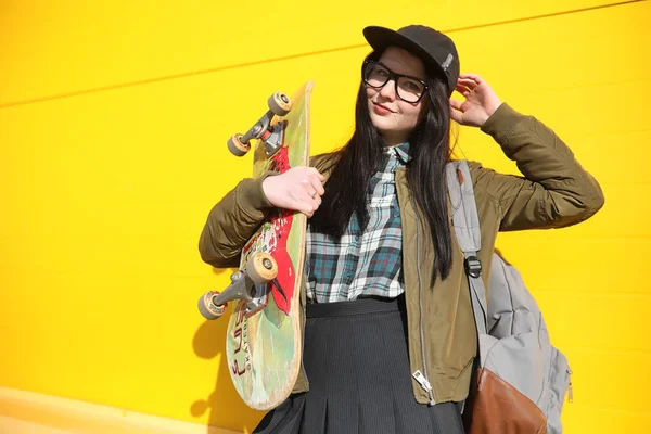 A young hipster girl is riding a skateboard. Girls girlfriends f — Stock Photo, Image