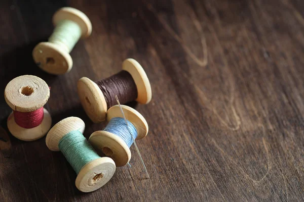 Filo da cucire su uno sfondo di legno. Set di fili su bobine — Foto Stock