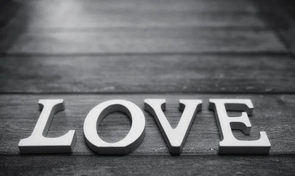 Palabra amor compuesta de letras de madera blanca sobre un fondo de madera — Foto de Stock