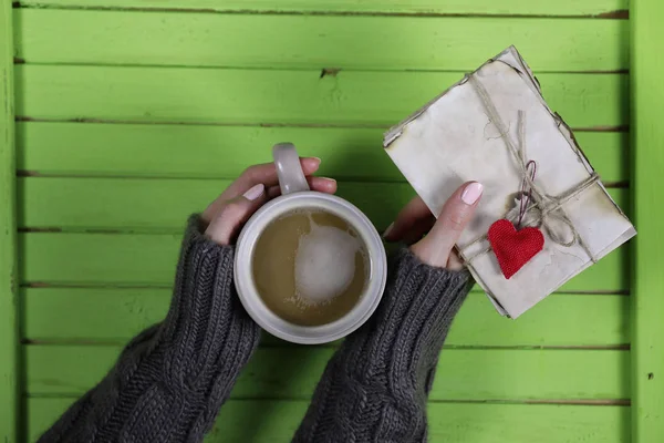 Girl drinking hot coffee and looks presented valentines — Stock Photo, Image