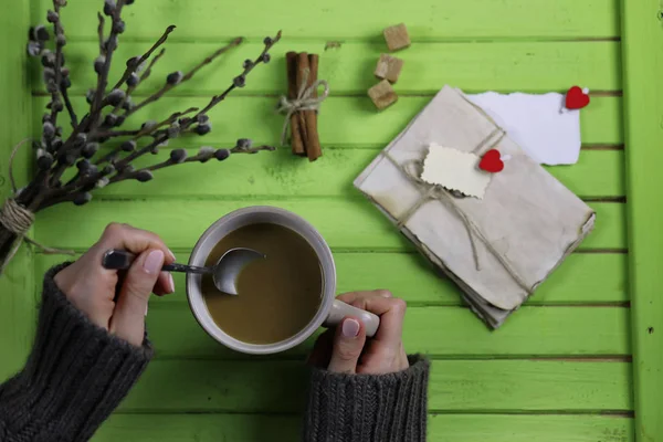 Girl drinking hot coffee and looks presented valentines — Stock Photo, Image