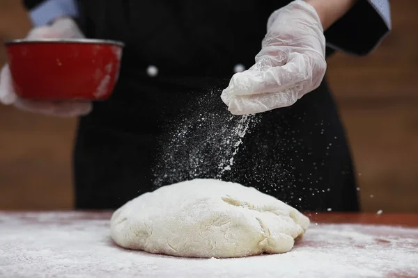 De kok maakt meel voor het bakken op tafel — Stockfoto