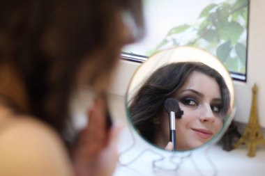 Güzel kız makyaj yapıyor.