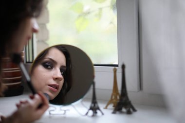 Güzel kız makyaj yapıyor.