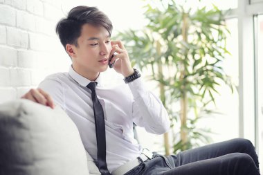 Genç Asyalı işadamı bir kafede bir ortak için bekliyor. Bu