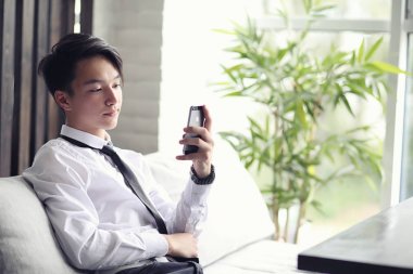 Genç Asyalı işadamı bir kafede bir ortak için bekliyor. Bu