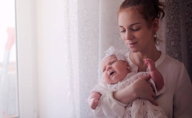 Anne kucağında yeni doğmuş bir bebekle. Kızın kucağında bir bebek var. 