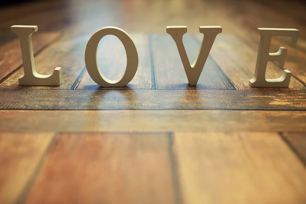 Slovo láska z dřevěných písmen na pozadí — Stock fotografie
