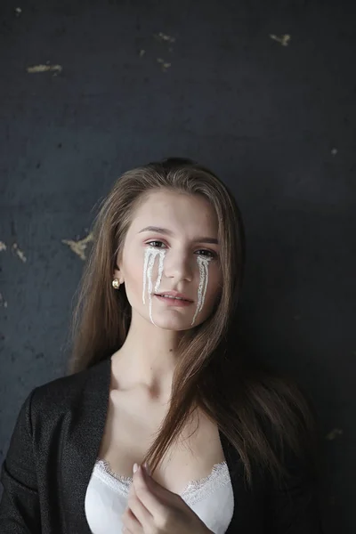 Beautiful girl with tears in her eyes. Young girl with painted t