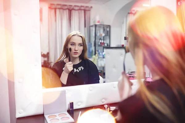Uma jovem faz maquiagem em um salão de beleza. A menina na frente o — Fotografia de Stock