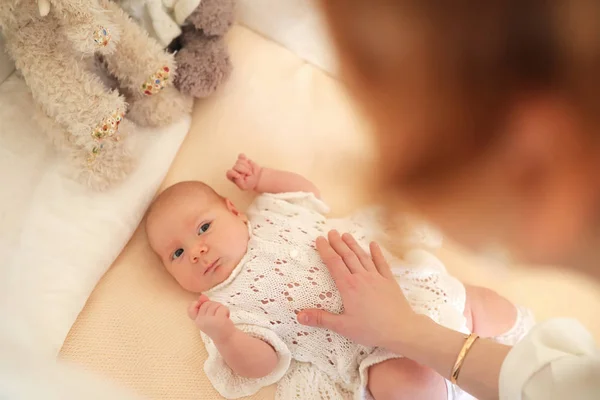 Pasgeboren schattig baby ligt in de wieg en op zoek moeder — Stockfoto