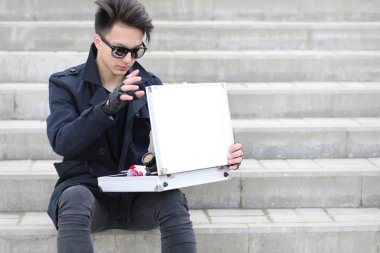 Metal bir bavulun içinde şehrin Asya adam. Asya ve gümüş ca