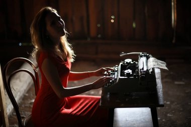 Retro tarzı bir kız üzerinde eski bir daktilo yazdırır