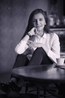 Bir kız bir kafede kahve içiyor. Bir kadın kahvaltı yapıyor