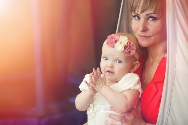 Bebek kız kollarında. Anne çocuğunu onun kollarında tutar. H