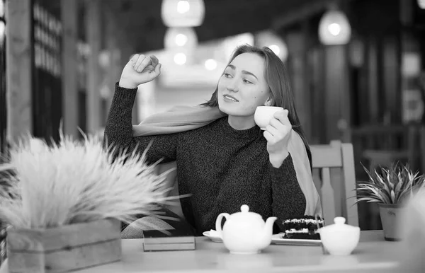 Flicka på ett café sitter och dricker te — Stockfoto