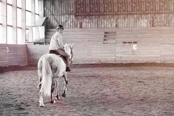 Jongeren op een paardentraining in houten arena — Stockfoto