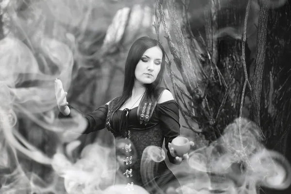 Mujer con traje de bruja en un bosque denso —  Fotos de Stock