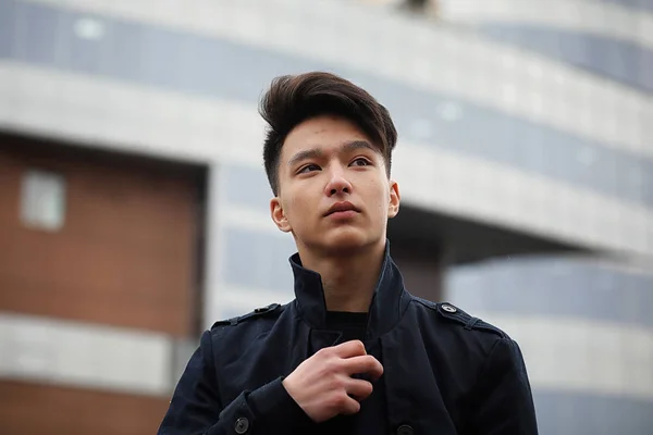 Asya genç adam sokakta bir ceket — Stok fotoğraf