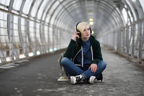 Ung flicka lyssnar på musik i stora hörlurar i tunnelbanan — Stockfoto