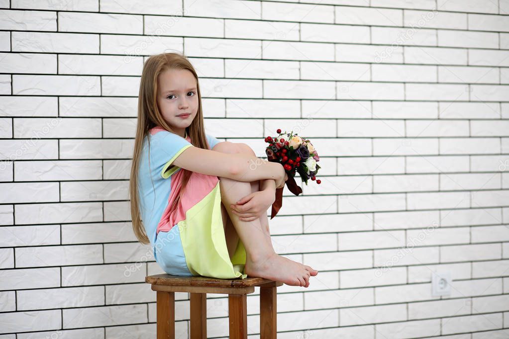little girl is sitting on a chair