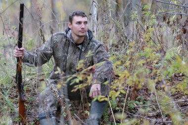 Kamuflaj ve bahar hun üzerinde orman Kuşağı'nda silahlı adam