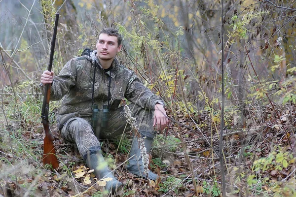 Ο άνθρωπος στο καμουφλάζ και με τα πυροβόλα όπλα σε ένα δάσος ζώνη σε μια άνοιξη hun — Φωτογραφία Αρχείου