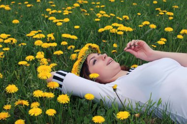 Sarı dandelions çayırda güneşli bir dinlenme kız